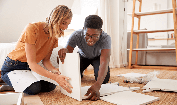Young couple assembling shelves at home